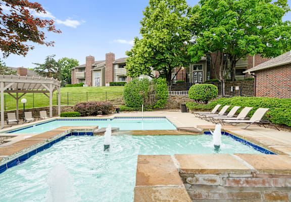 A pool with a fountain in the middle of it.