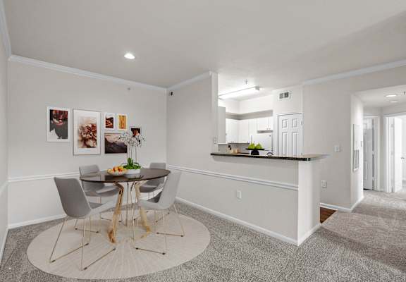 a dining area with a small table and four chairs