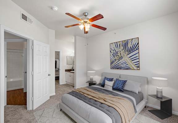 a bedroom with a bed and a ceiling fan