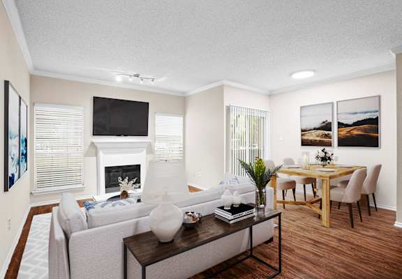 a living room with a fireplace and a dining room in the background