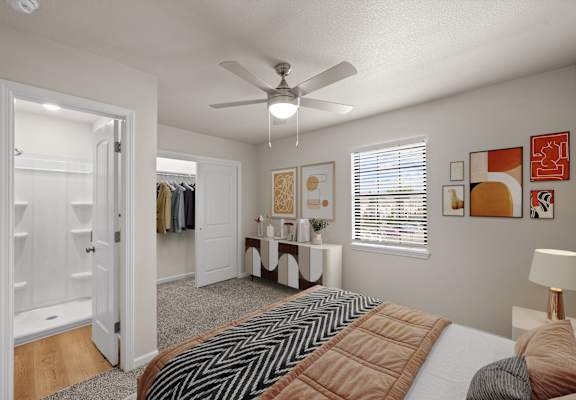 A bedroom with a large bed and a ceiling fan.