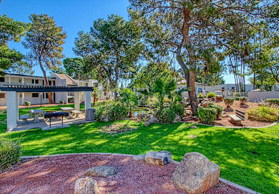 A house with a patio and a garden in front.