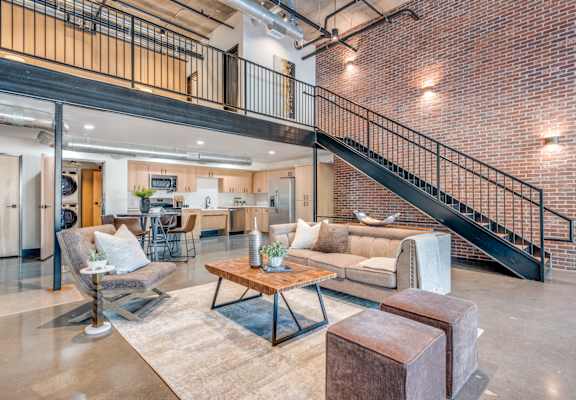 A living room with a couch, chairs, and a coffee table.