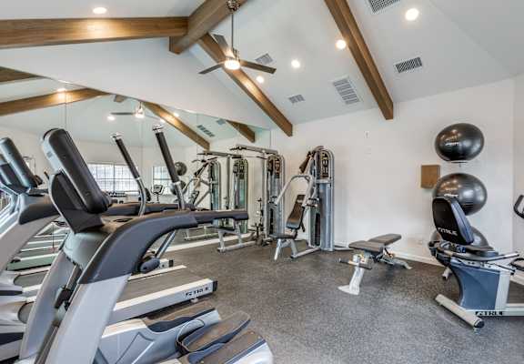A spacious gym with a variety of equipment including treadmills, weights, and exercise balls.