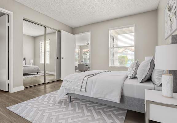 A bedroom with a large bed and a patterned rug.