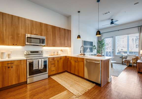 A modern kitchen with wooden cabinets and stainless steel appliances.