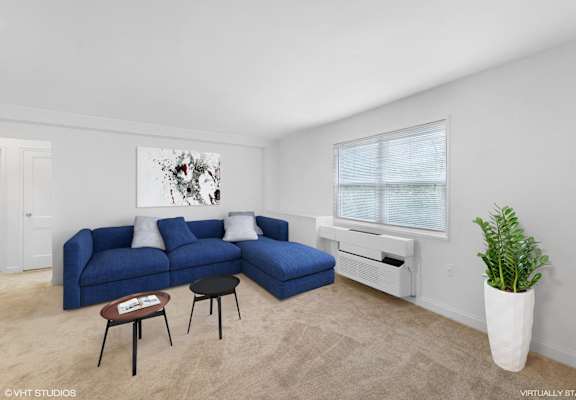 an open living room with a blue couch and a window