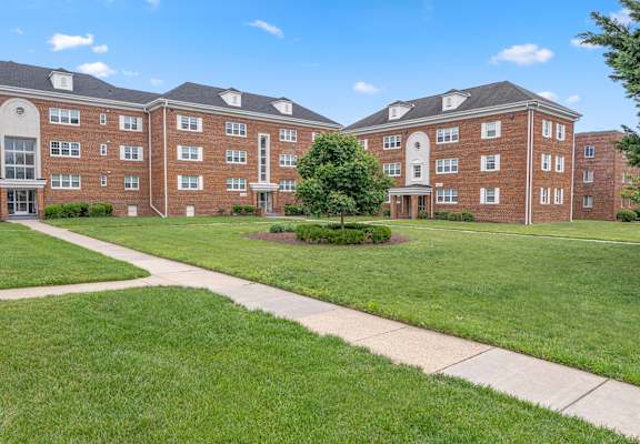 A large red brick building with a green lawn in front.