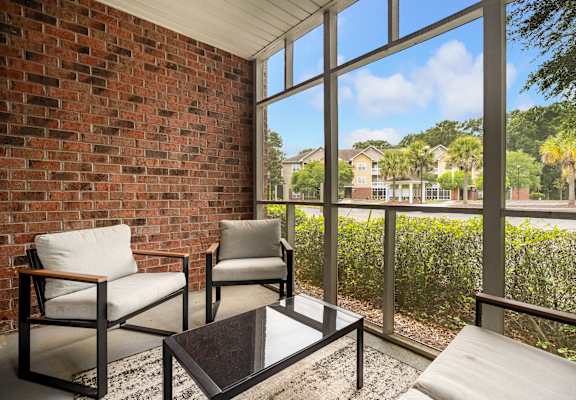 Two chairs and a coffee table in front of a window.
