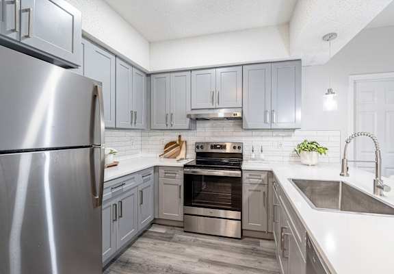 A modern kitchen with a stainless steel refrigerator and a double oven.