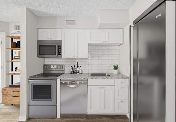 a kitchen with white cabinets and stainless steel appliances