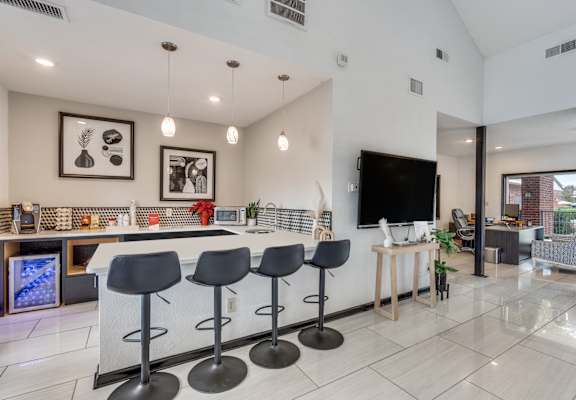A modern kitchen with a bar area and a television.