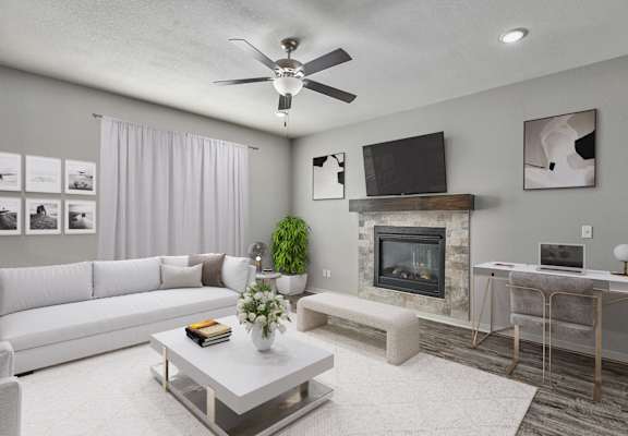 A living room with a fireplace, a television, and a white couch.