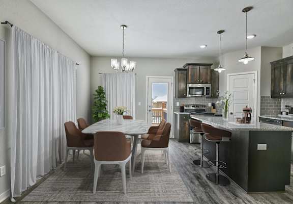 A modern kitchen with a dining table and chairs.
