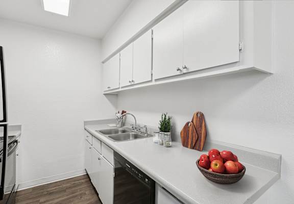 A kitchen with a bowl of apples on the counter.