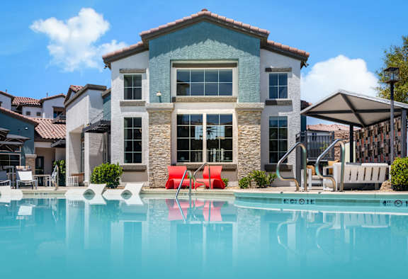 A large house with a pool in front. at Miro at the Parc Apartments, Henderson , NV, 89074