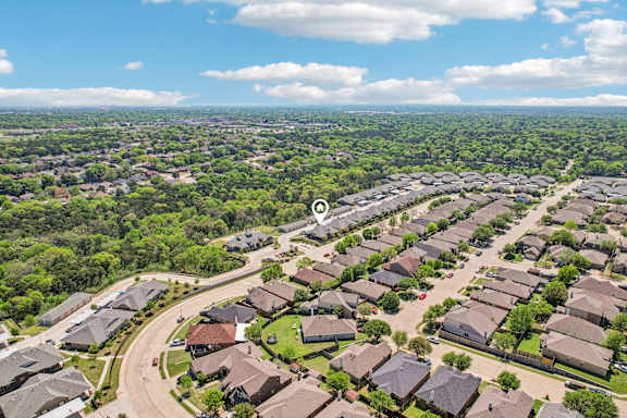 A bird's eye view of a residential area with houses surrounded by greenery.