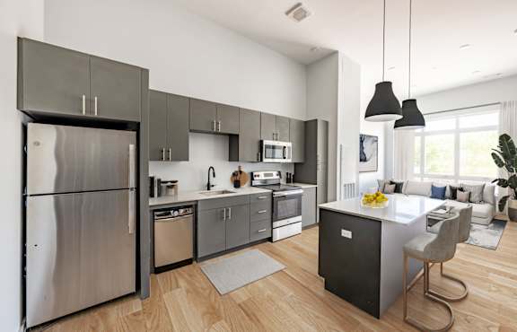 A modern kitchen with a stainless steel refrigerator and wooden flooring. at Seacoast Residences Apartments, Oakland, ME, 03904
