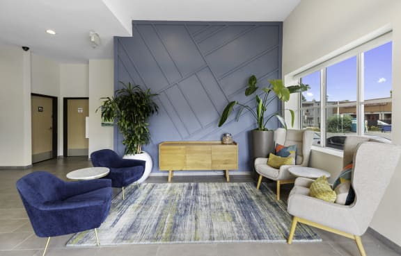a living room with a couch table and chairs and a kitchen in the background at Arabella Apartment Homes in Shoreline, WA