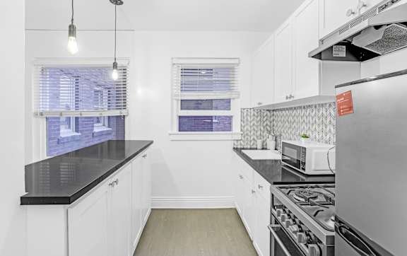 A kitchen with white cabinets and a black countertop. at Park Wilshire, Los Angeles, CA