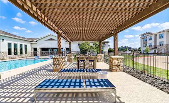 A wooden pergola over a blue and white checkered table.