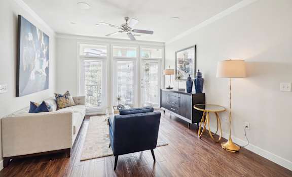 a living room with a couch and a chair and a ceiling fan
