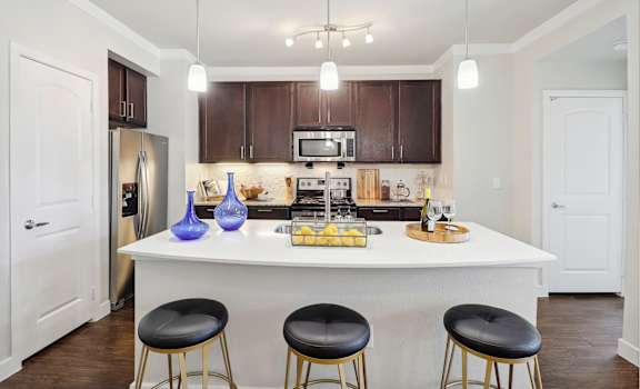 a kitchen with a large island with three stools