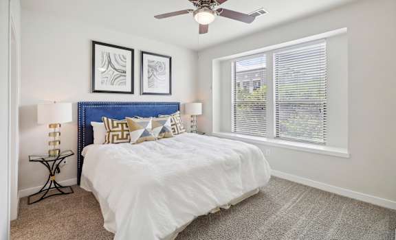 a bedroom with a bed and a ceiling fan