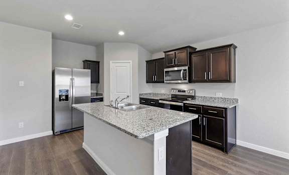 a kitchen with a granite counter top and a stainless steel refrigerator