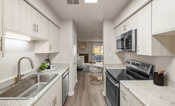 A modern kitchen with a stainless steel sink and oven.