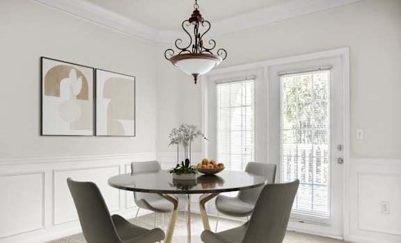 A dining room with a round table and chairs.
