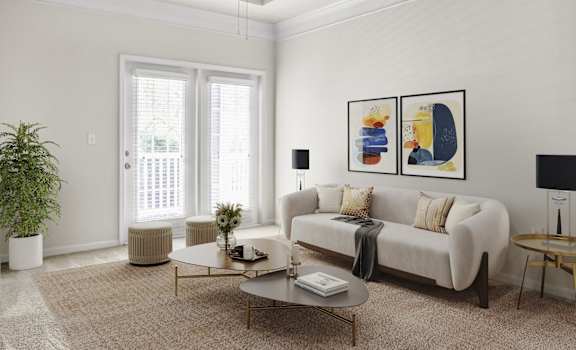A living room with a white sofa, a coffee table, and a potted plant.