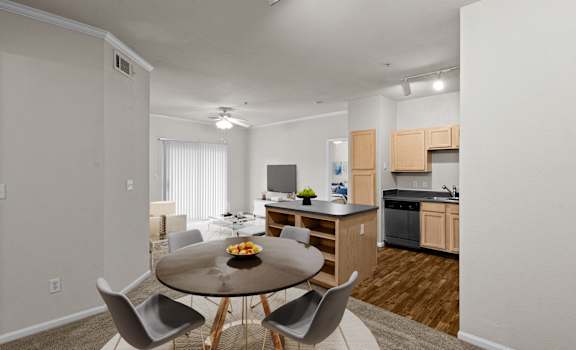 A modern kitchen with a dining table set for four.