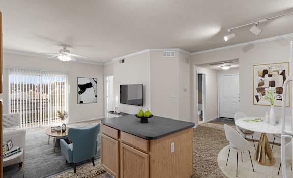 A well-lit kitchen and living room with modern furniture.