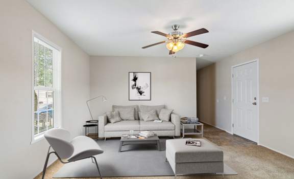 A living room with a white couch, a grey chair, and a coffee table.