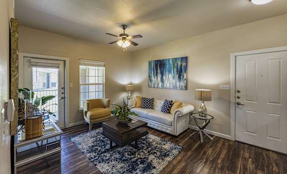A living room with a couch, chair, and a painting on the wall.