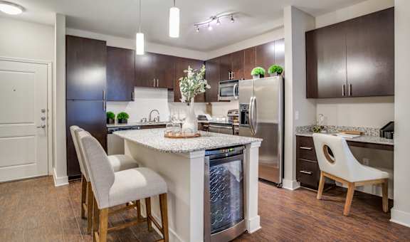 A kitchen with a white island and brown cabinets.