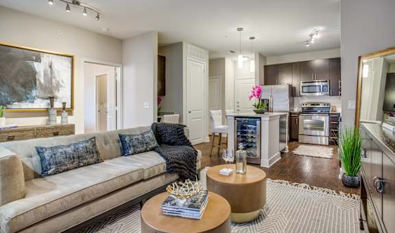 A modern living room with a beige couch and a coffee table in the center.