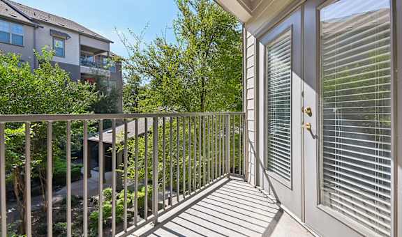 the view from the balcony of a home with a door to the yard