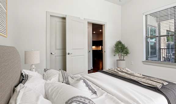 a bedroom with a large bed and a door to a bathroom