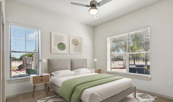 a bedroom with a bed and two windows