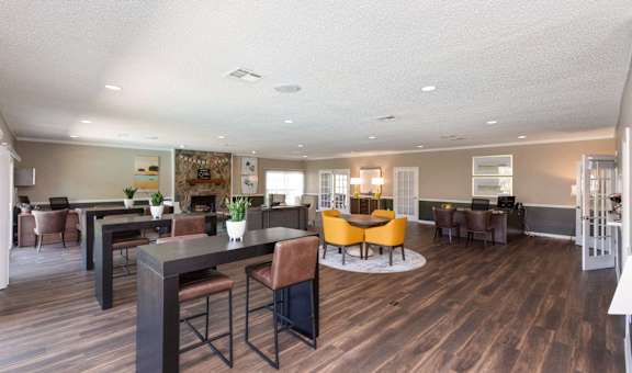 a community room with tables and chairs and a fireplace