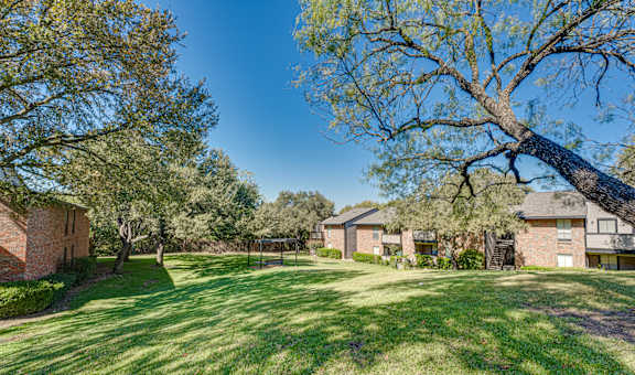 A large grassy area with trees and houses in the background. at Southern Oaks, Texas, 76132