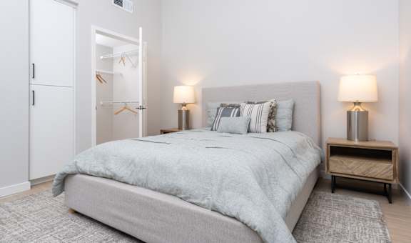 A bedroom with a bed, nightstands, and a wardrobe.