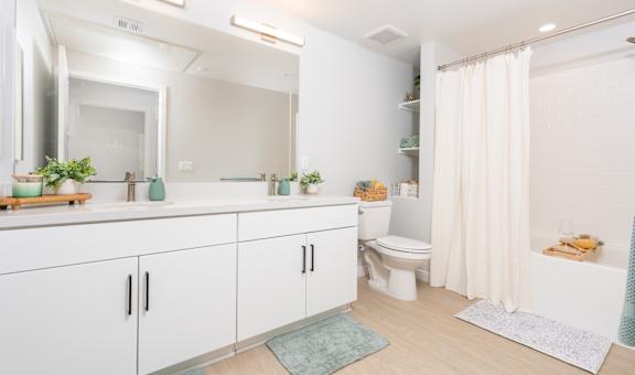 A white bathroom with a toilet, sink, and mirror.