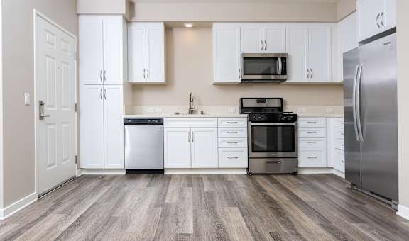 a kitchen with white cabinets and stainless steel appliances