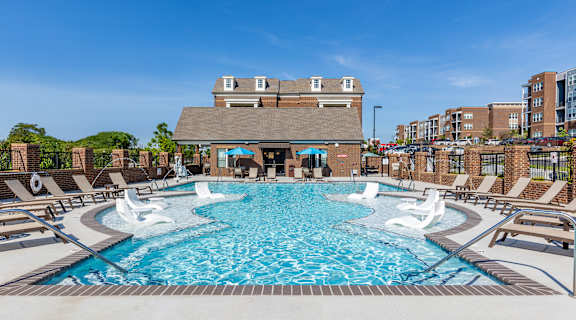 A large swimming pool with a building in the background.