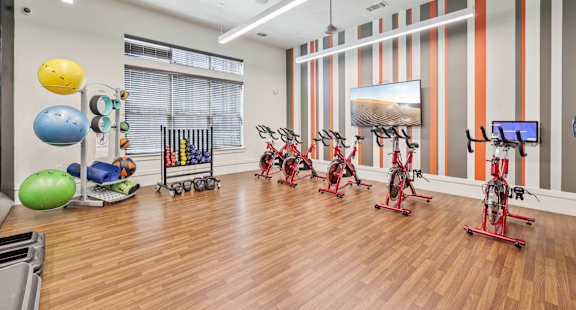 A gym with exercise equipment and a TV.at North Creek, Hutto, TX, 78634