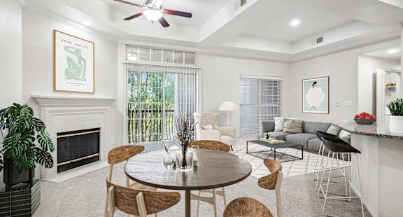 a living room with a table and chairs and a fireplace at La Ventura Apartments, Texas