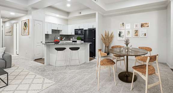 a living room with a kitchen and a dining table at La Ventura Apartments, Texas